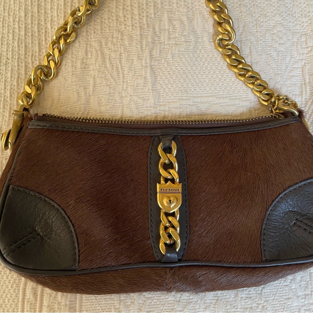 Juicy Couture 9”x2”x4”. Heavy chain strap.Cowhide and leather.Brown in color.